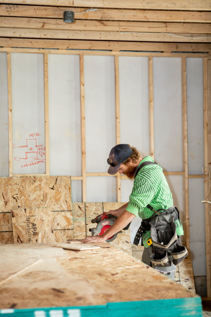 Carpenter cutting planks of plywood

